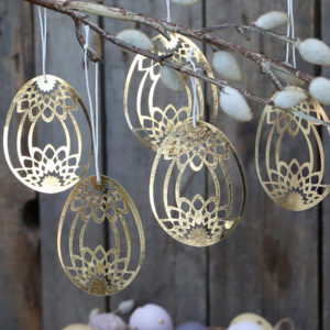 5 papercut Easter egg decorations hanging from branches