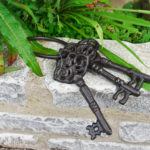 bunch of cast iron antique style keys on a garden wall