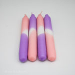 Dip Dyed candles in pink and purple lying in a row