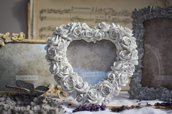 heart shaped photo frame in white with cream frame and vintage sheet music in the background