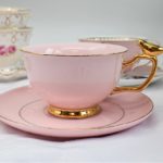Pink cup and saucer with gold trim and gold bird on the handle