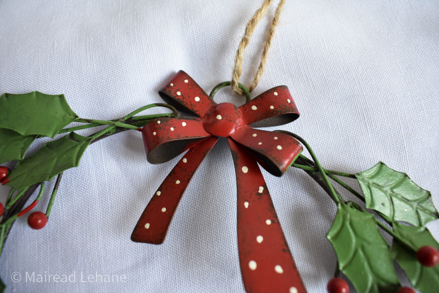 close up fo metal wreath with red and white bow