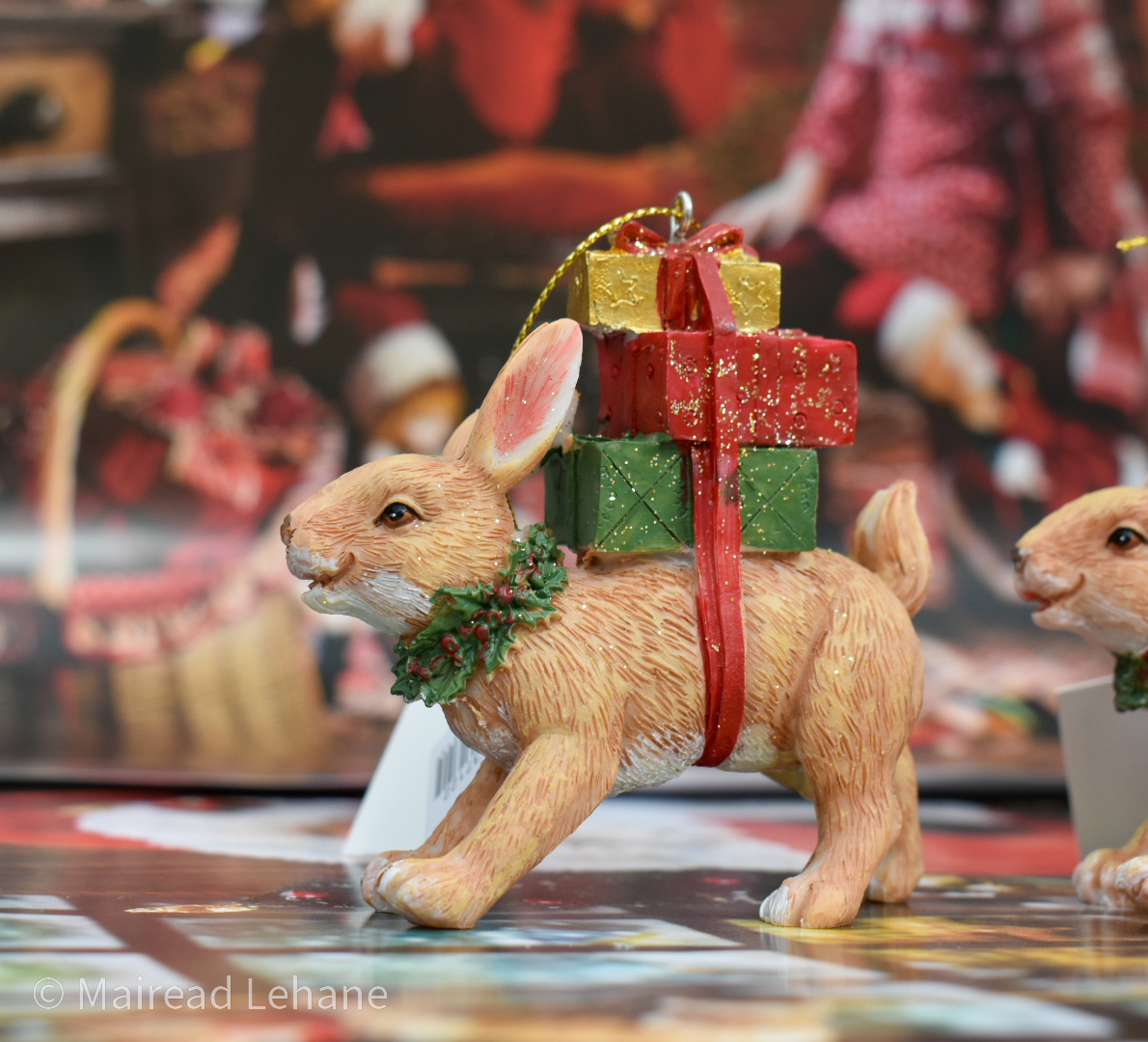 Rabbit Christmas decoration with 3 gifts tied to its back and a wreath around its neck