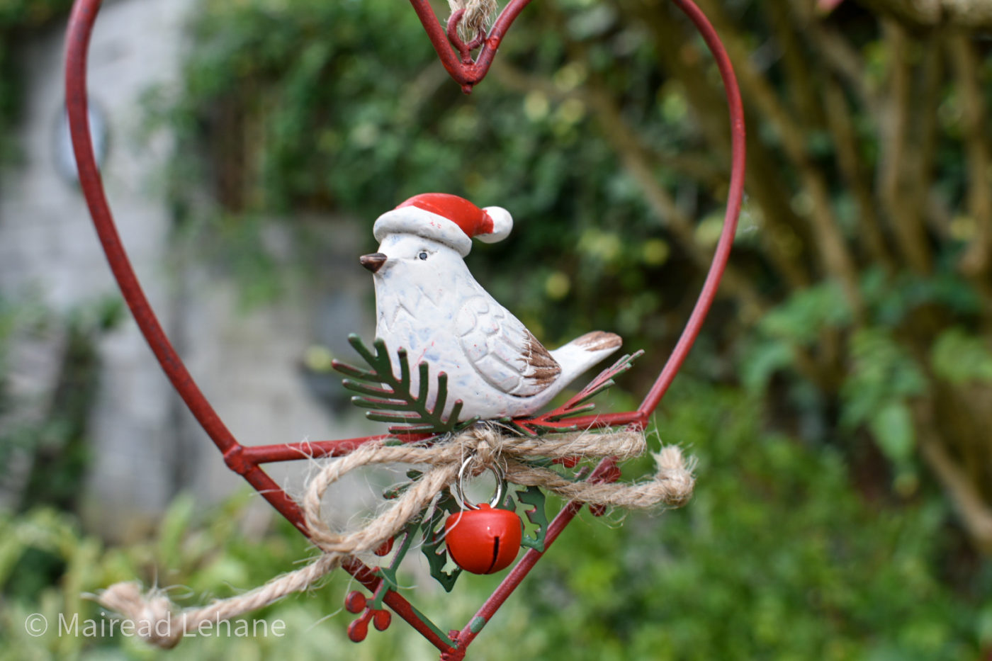 white bird decorative bird feeder in a red heart with string and a small red bell