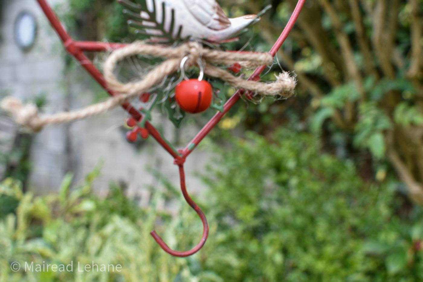 red hook for hanging bird food at the base of a heart shaped bird feeder decoration