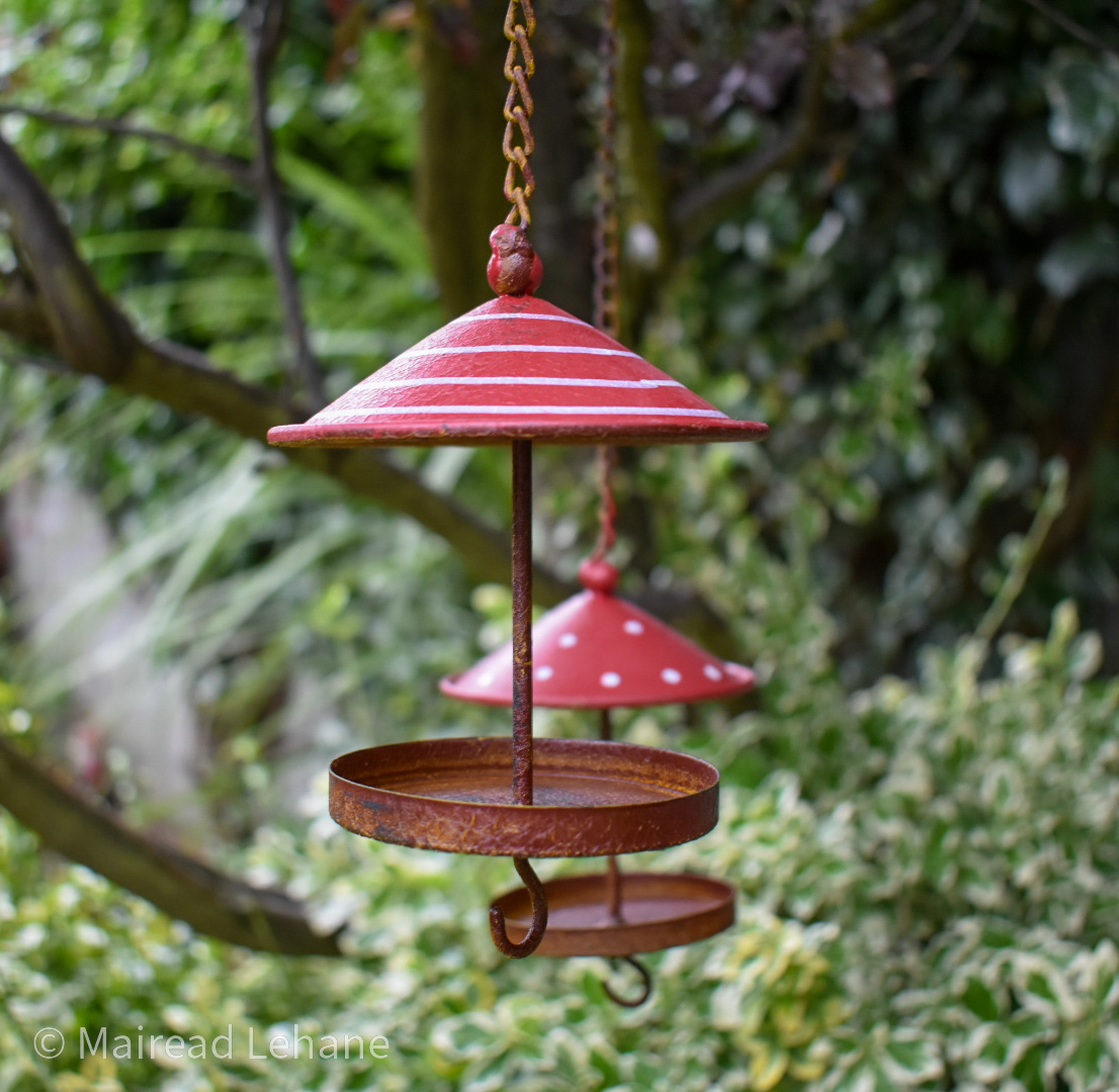 hanging bird houses with red and white umbrella type tops