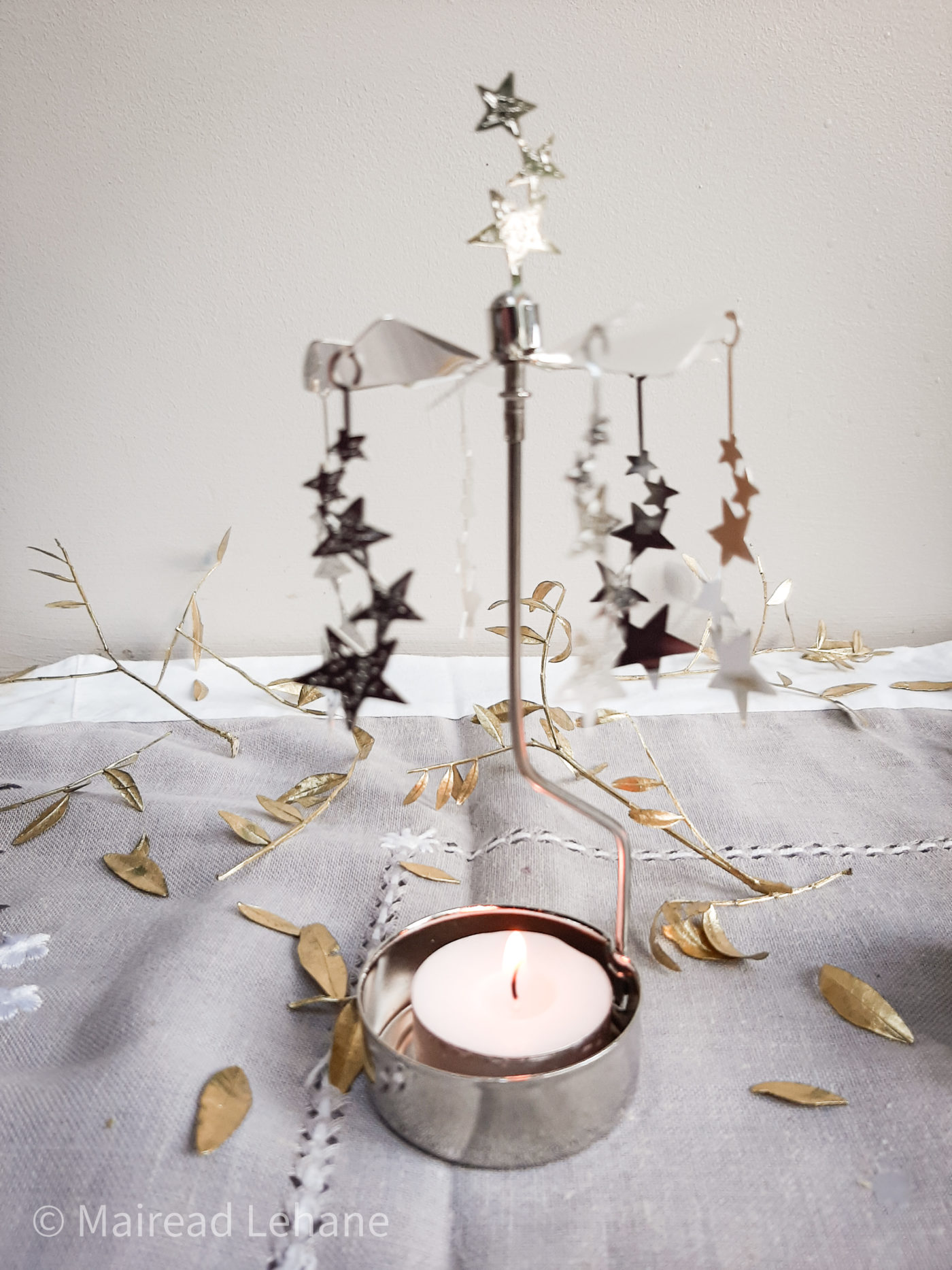 rotating candle holder with rows of stars on a spinner which rotate when the candle is lighting