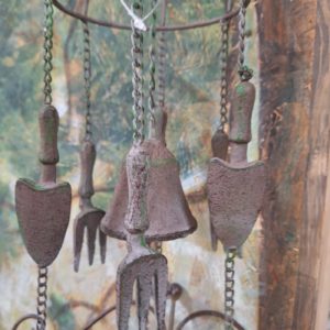 Wind chimes of garden tools hanging with a green garden background